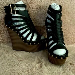 Faux stacked wedge sandal with strappy caged design and back zip closure.